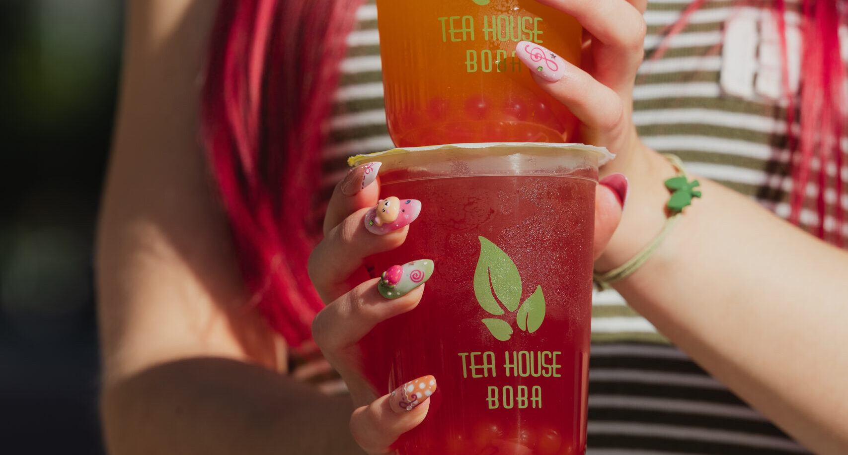 Model holding a Tea House Boba drink